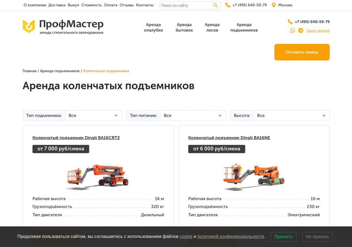 Красный коленчатый подъемник работает на строительной площадке, поднимая рабочих к фасаду здания.